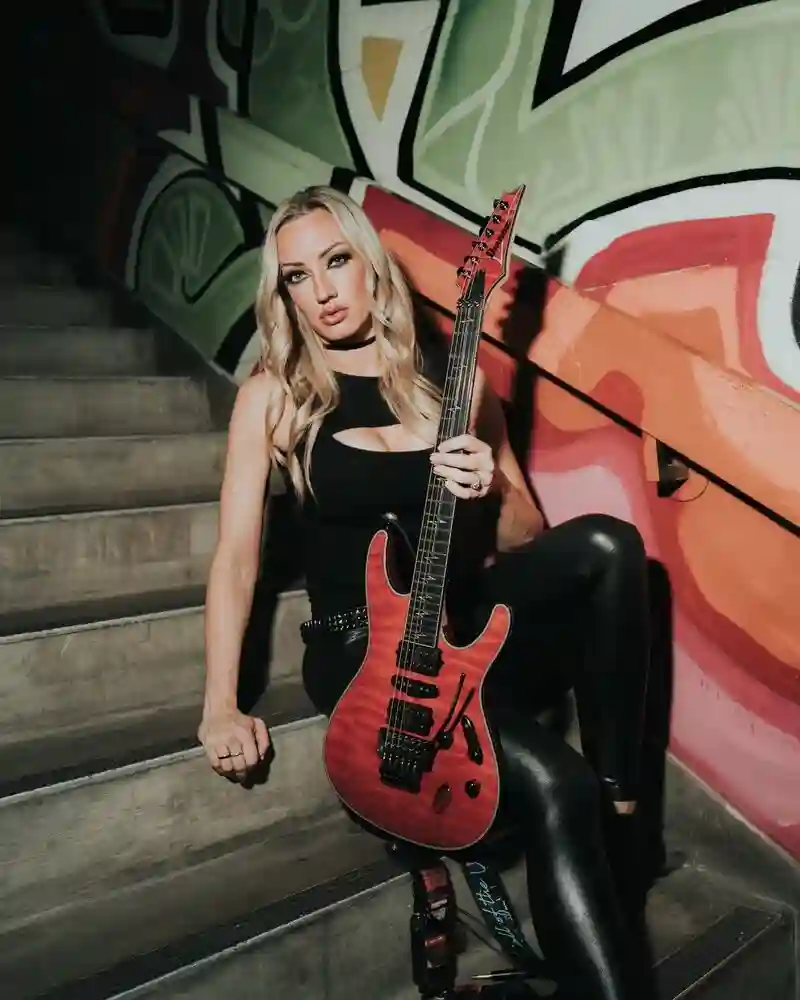 Nita Strauss showing toned figure with guitar